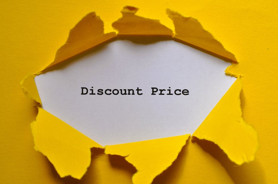 A piece of bright yellow paper is torn open to reveal a white interior with the words 'Discount Price' printed in black. The torn edges are irregular and jagged, creating a layered effect that exposes the message. The background is also yellow, matching the outer paper, and the image is evenly lit to highlight the contrast between the torn paper and the printed message, conveying a promotional or price-related concept that could be associated with house removals or relocation services, such as offering discounted moving quotes or reductions on removal fees. The visual style emphasizes the revealing of a special deal within a typical packing or promotional context, relevant to the domain of professional removals like Man with Van Addiscombe.